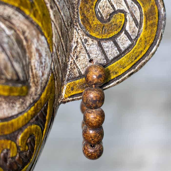 Máscara tribal entalhada à mão em madeira, inspirada na cultura de Bornéu e produzida artesanalmente em Bali.