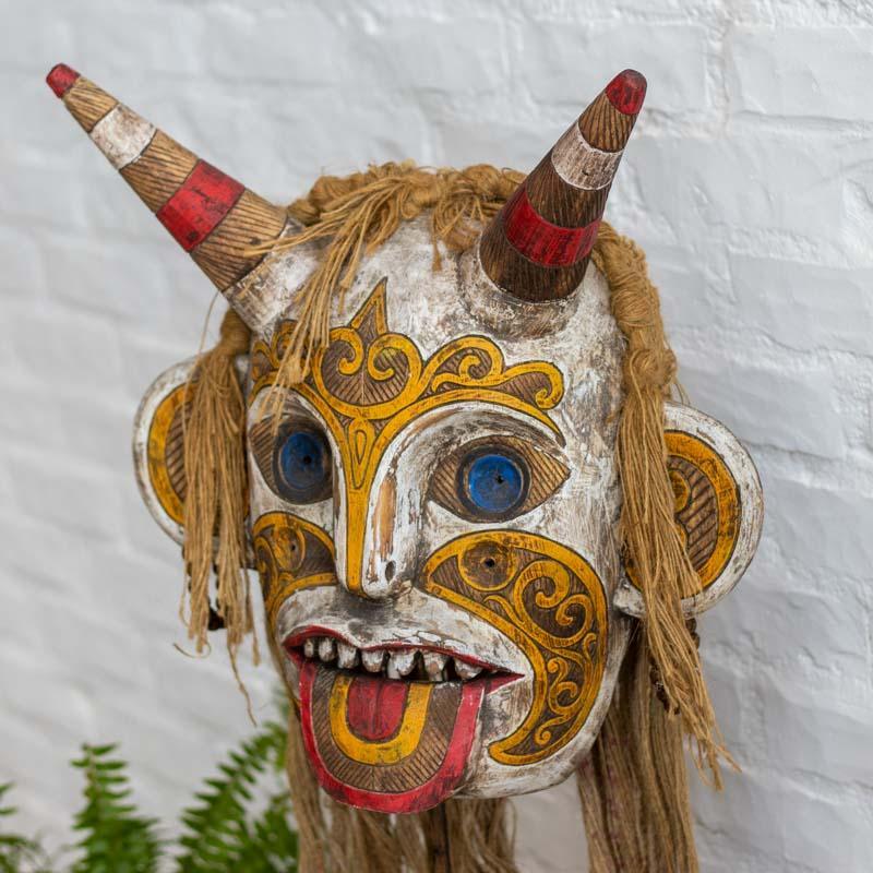 Escultura de madeira com pátina colorida e traços expressivos, peça exclusiva de Bornéu para decoração de interiores.