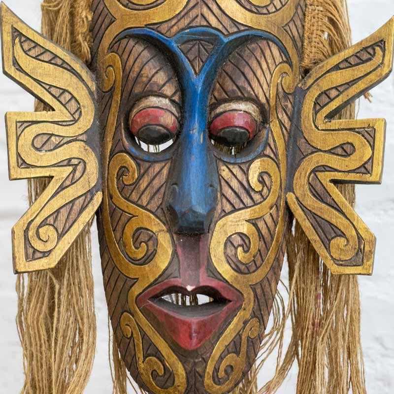 Escultura com traços tribais marcantes e formato vertical para exposição.