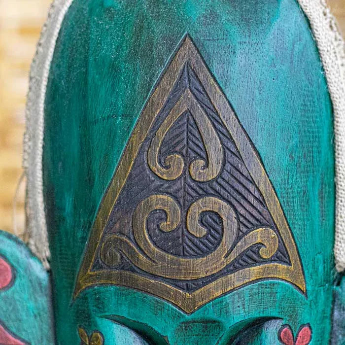 Objeto decorativo em madeira com traços esculpidos à mão por artesãos locais.