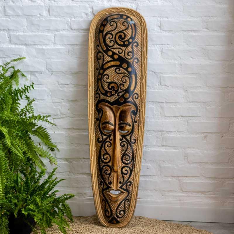 Objeto de arte tribal exclusivo da Indonésia, mostrando a face alongada e os traços primitivos da máscara Bornéu.
