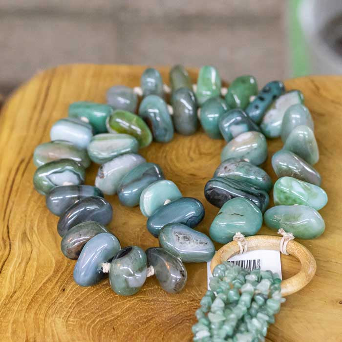 Peça decorativa com pedras naturais verdes e tassel artesanal.