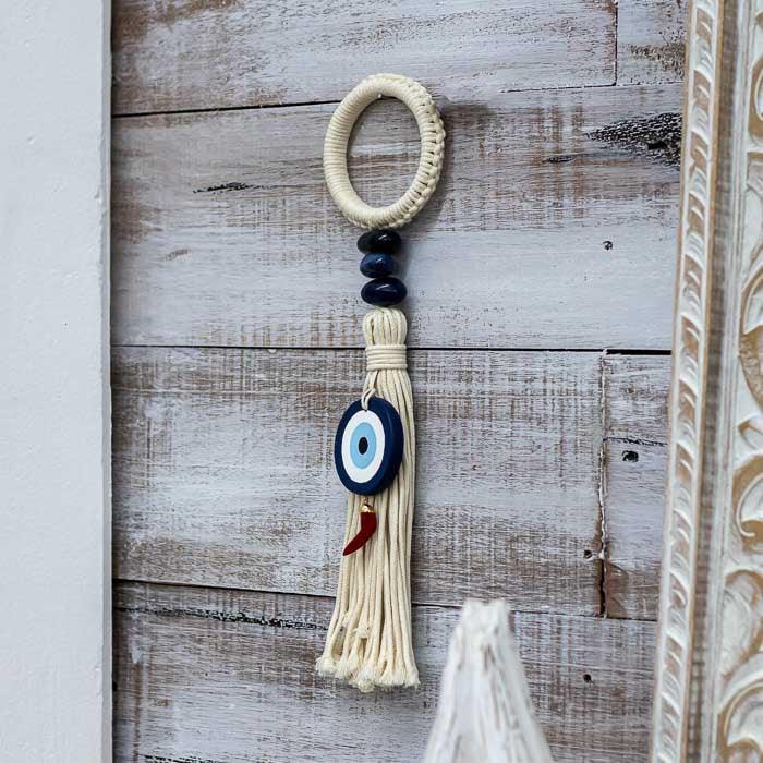 Peça decorativa espiritual com símbolo do Olho Grego e pendente de pimenta.