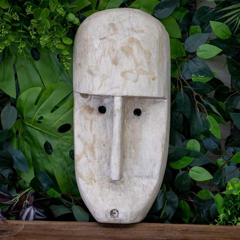 Máscara étnica alongada de Timor em madeira clara com pátina branca e design minimalista primitivo.