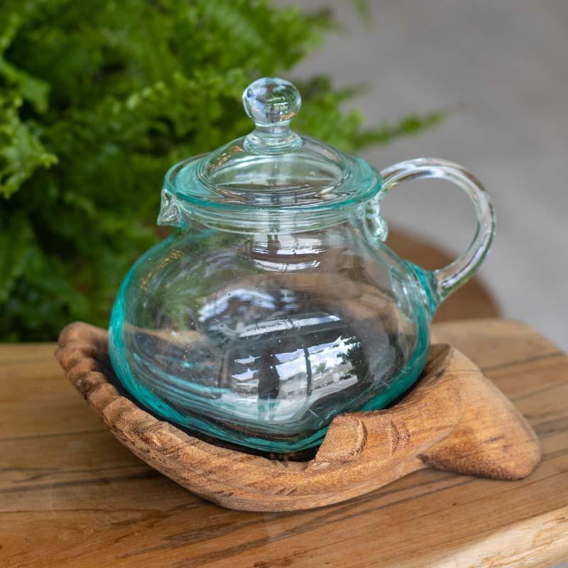 Detalhe da jarra de vidro soprado com tampa sobre base entalhada.