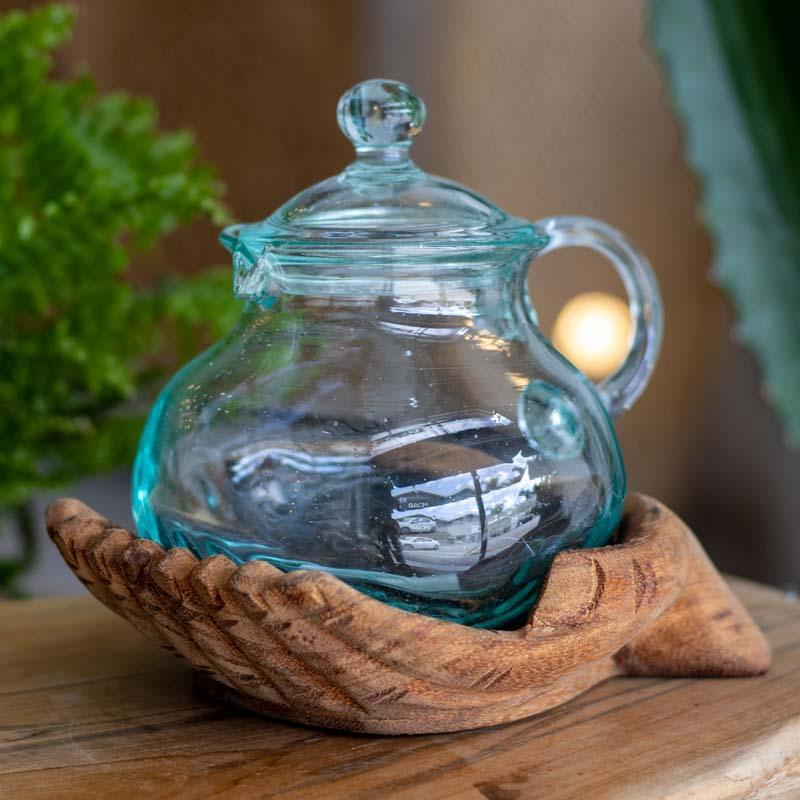 Jarra de vidro soprado artesanal com tampa em bandeja de mãos entalhadas.