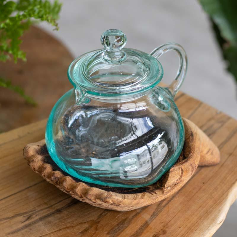 Objeto decorativo em vidro soprado com base de madeira entalhada.