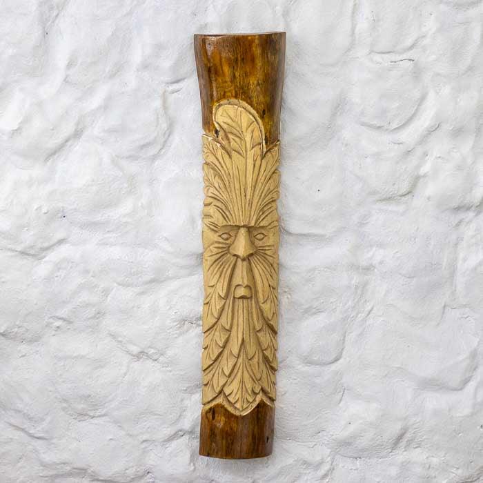 Escultura no tronco com entalhe detalhado do rosto ancestral Green Man.