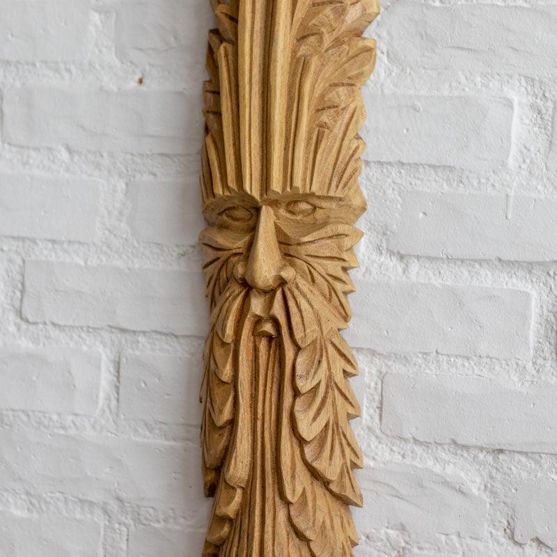 Escultura de parede em tronco com representação naturalista do Green Man.