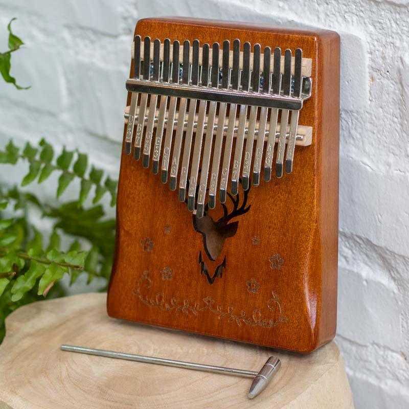 Instrumento musical Kalimba artesanal de Bali em madeira com entalhe de cervo e teclas metálicas afináveis.