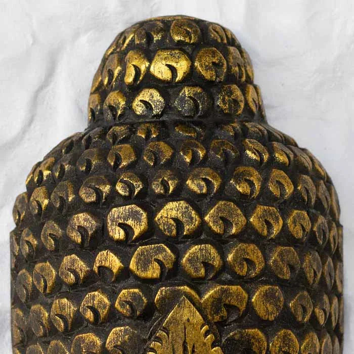 Detalhe da máscara Buda dourada com entalhes finos e brilho suave.