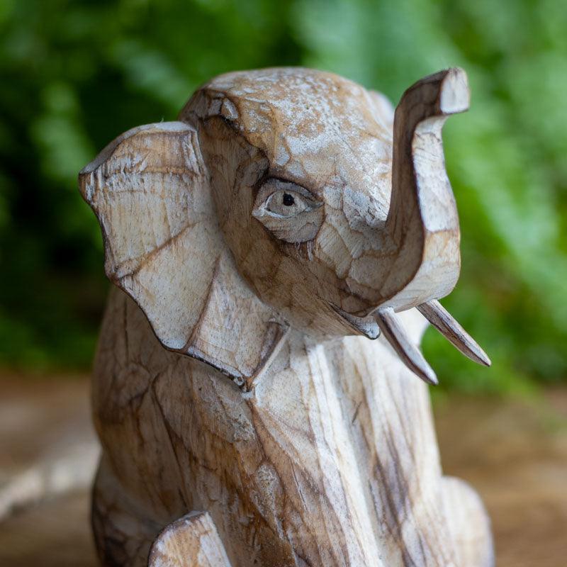 Arte balinesa: escultura artesanal de elefante sentado em madeira.