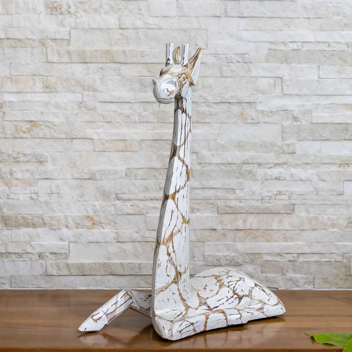 Escultura artesanal de girafa deitada entalhada em madeira natural