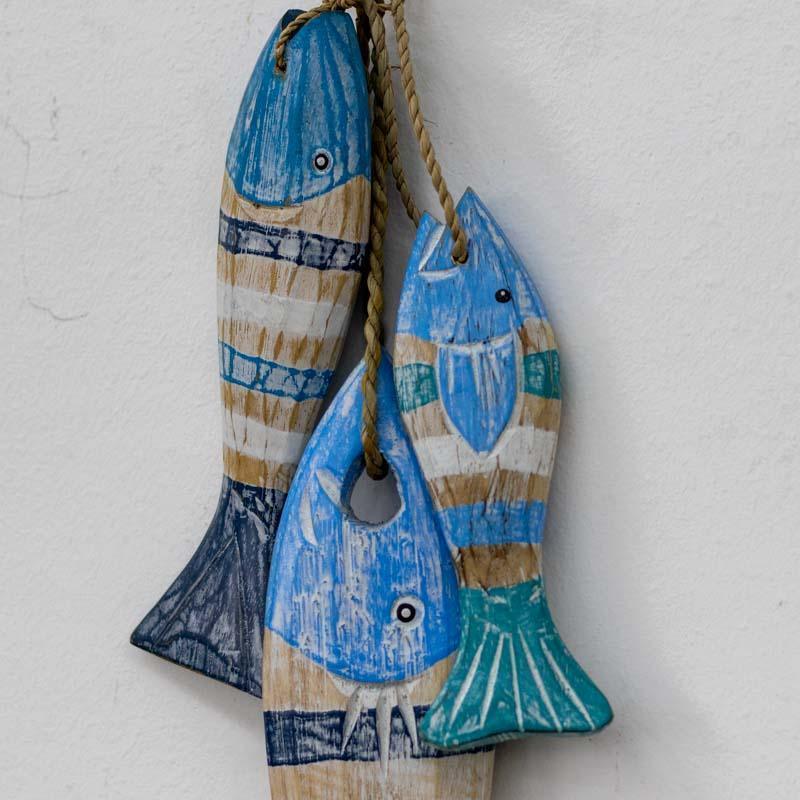 Decoração boho com esculturas de peixes em madeira pintada