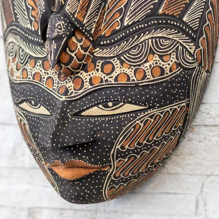 Máscara entalhada à mão com detalhes pintados em Batik, refletindo a riqueza artística de Bali e da Indonésia