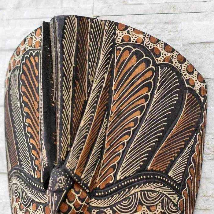Peça decorativa em madeira com aplicação do Batik, tradicional arte têxtil adaptada à pintura de máscaras balinesas