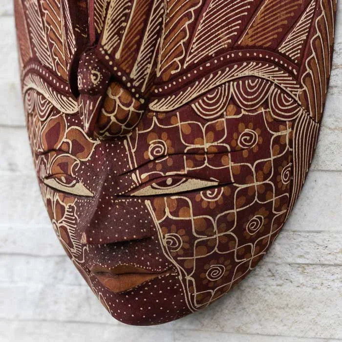 Máscara feita à mão em madeira com influência Batik, mesclando texturas visuais e significados ancestrais