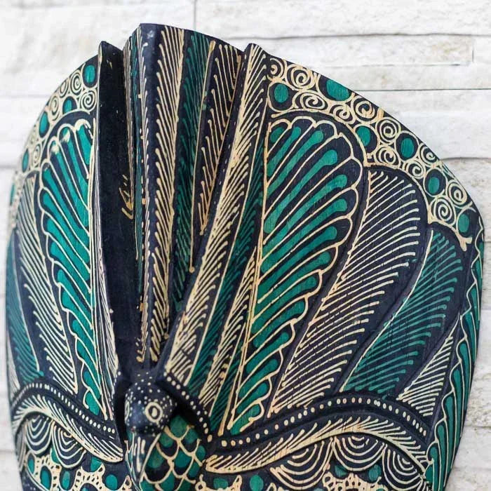 Máscara com influência tradicional de Bali, produzida em madeira e ornamentada com pintura Batik manual