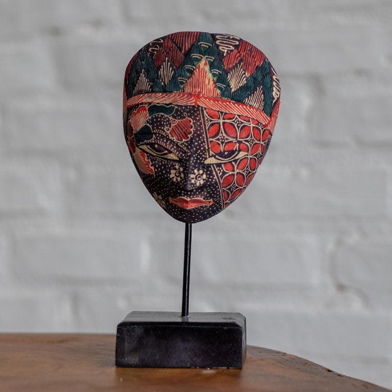Objeto de arte oriental com estampa artesanal exclusiva posicionado sobre superfície de madeira rústica.