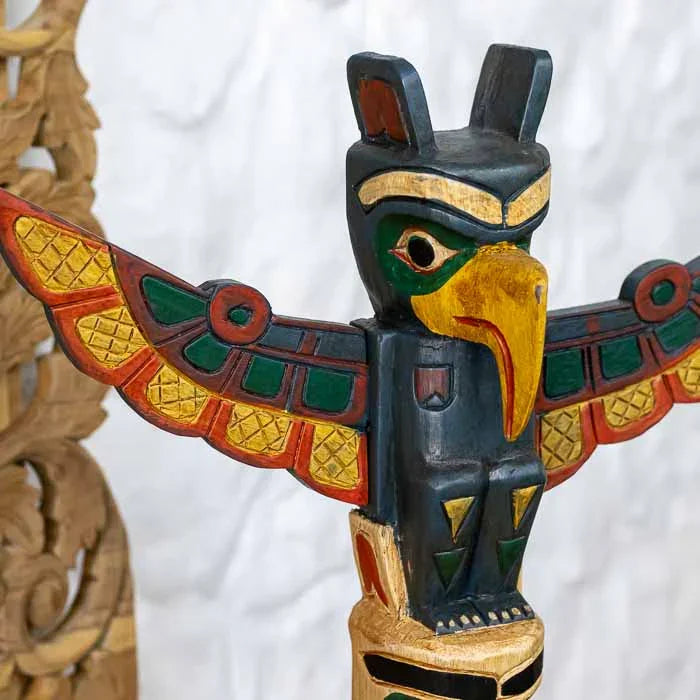 Escultura totem em madeira artesanal com figuras totêmicas estilizadas.