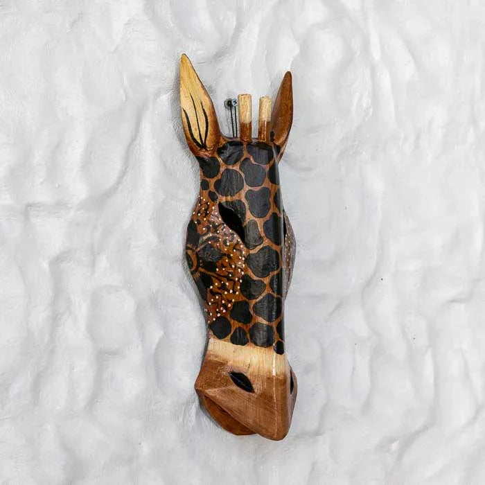 Arte balinesa em madeira representando girafa tribal com entalhes finos.