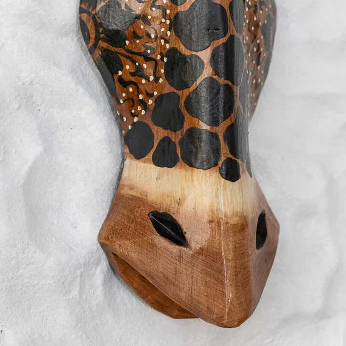 Escultura de parede em madeira natural retratando girafa tribal.