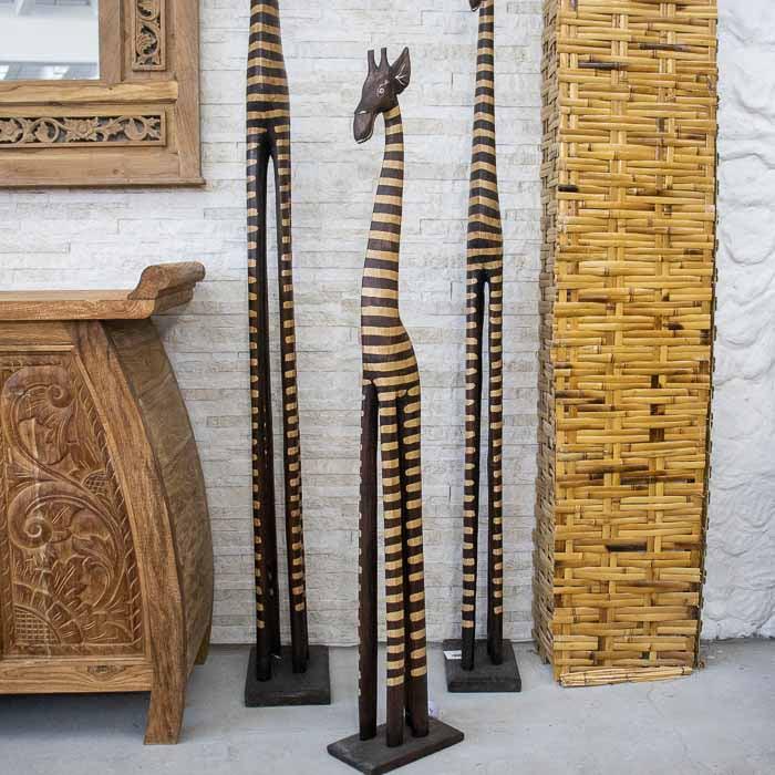 Detalhe da girafa artesanal em madeira de Bali com acabamento natural.