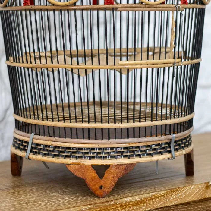 Arte em fibra natural de Bali: gaiola com topo trabalhado e detalhes em vermelho.