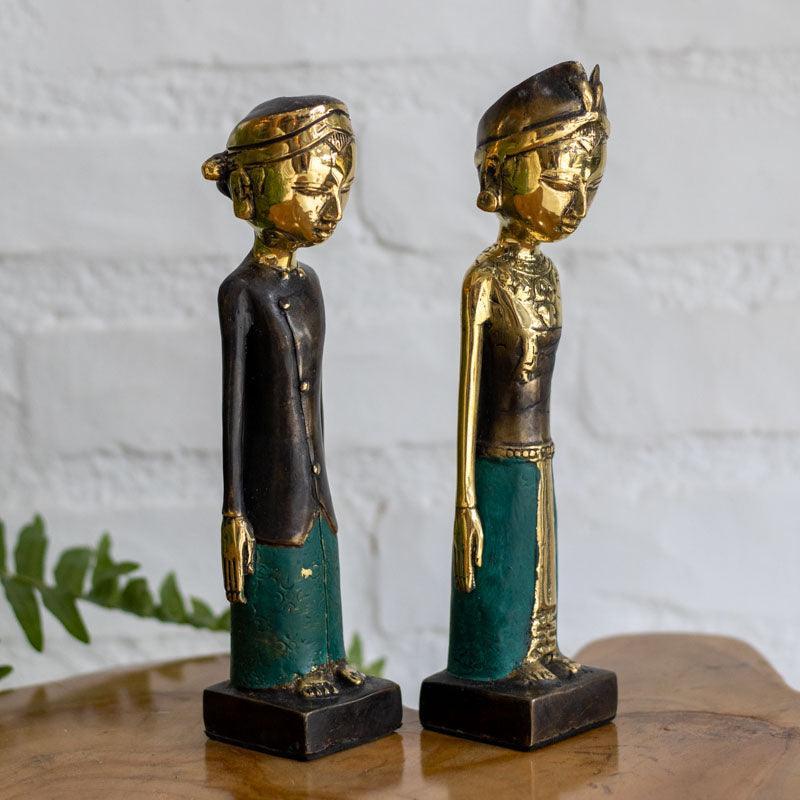 Detalhe do rosto e coroa dourada de estátua Loro Blonyo feminina em bronze polido.