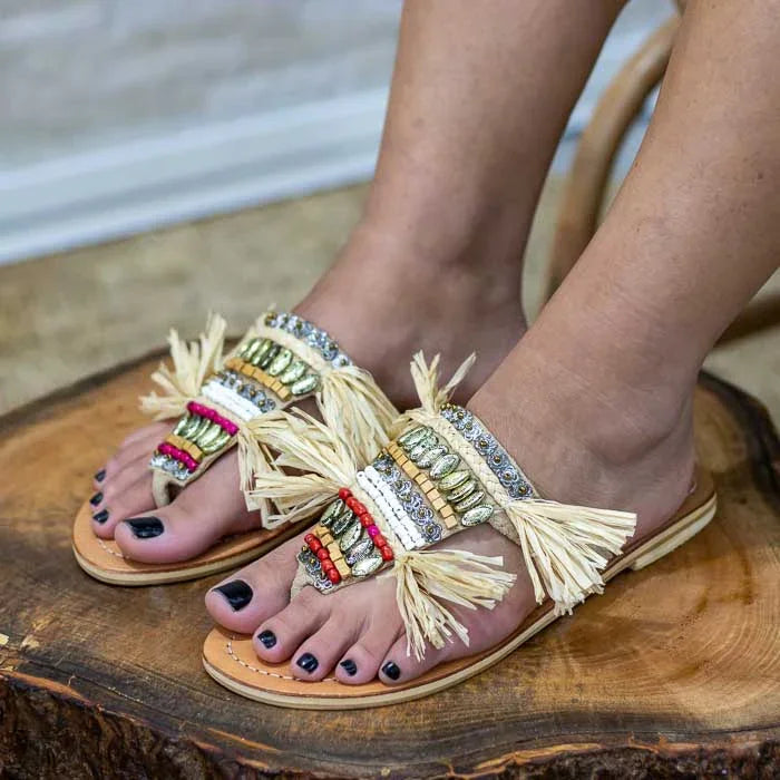 Sandália artesanal com fibra natural trançada e aplicação de miçangas.