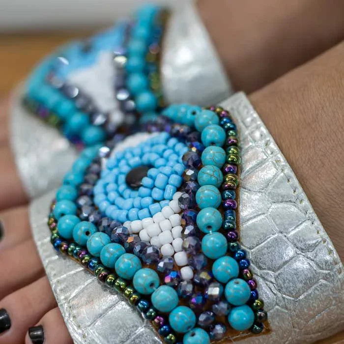Calçado artesanal com estilo boho e acabamento detalhado com miçangas.
