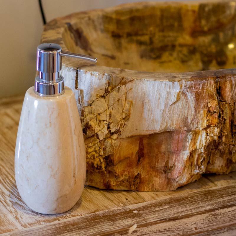 Dispenser de sabonete líquido em pedra natural sobre bancada, peça exclusiva de decoração balinesa.