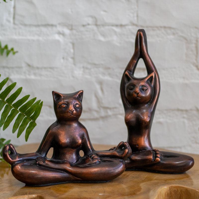Peça decorativa em fibrocimento representando gato em postura meditativa.