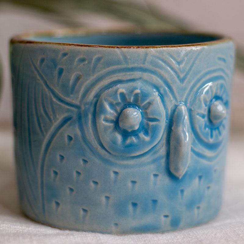 Caneca turquesa artesanal em cerâmica com relevo de coruja.