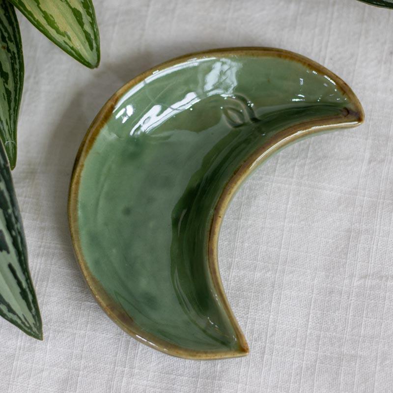 Travessas artesanais de Bali em formato de meia lua com rosto esculpido nas cores branco, verde e turquesa com borda dourada.