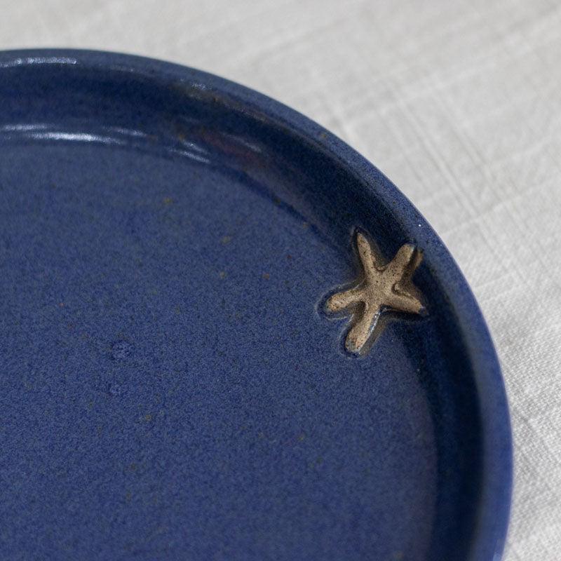 Prato decorativo artesanal em cerâmica azul profundo com detalhe de estrela-do-mar em relevo, importado de Bali.