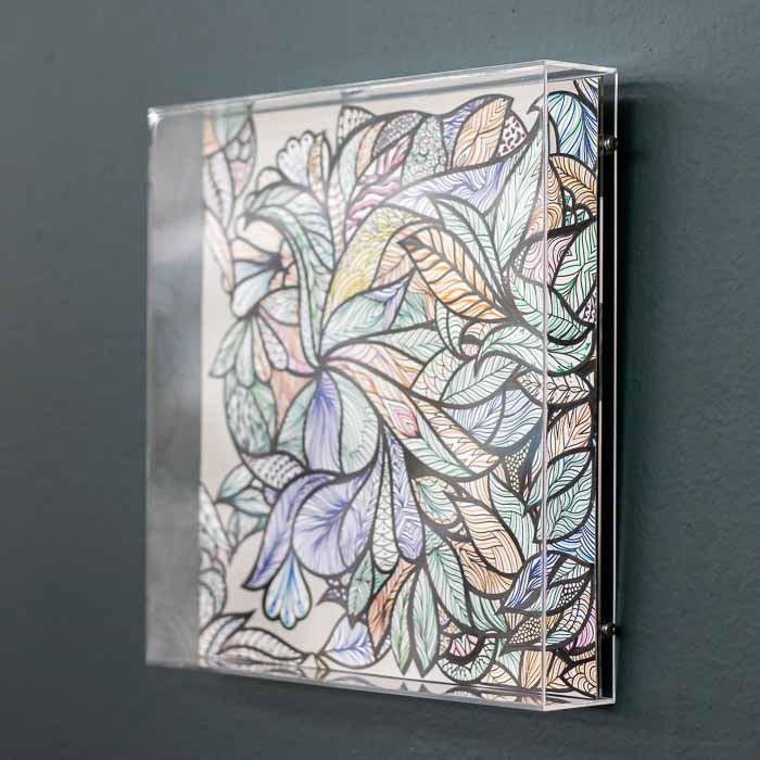Obra decorativa floral em caixa acrílica com materiais reciclados.