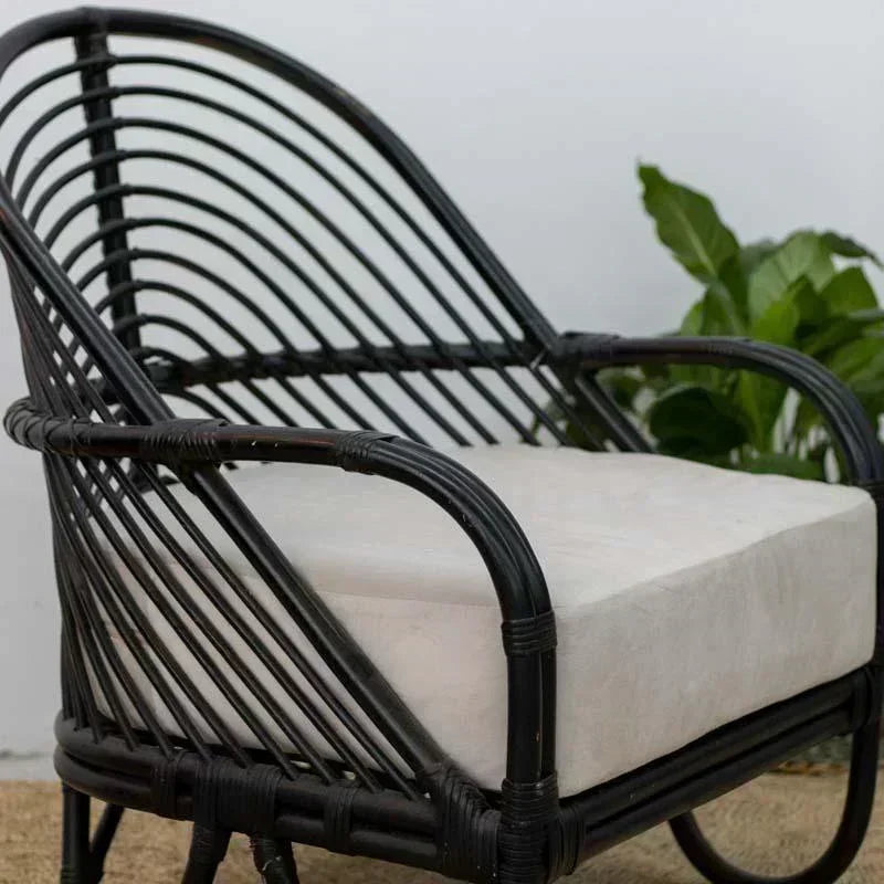 Poltrona de luxo com contraste entre estrutura preta e tecido neutro, trazendo sofisticação orgânica para o lar.