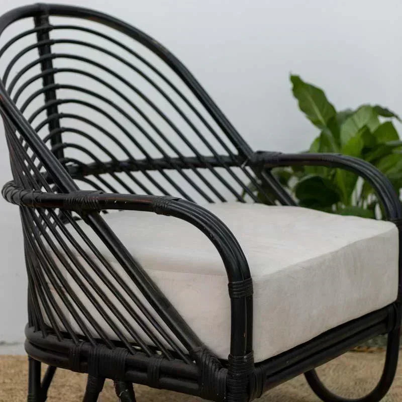 Poltrona de luxo com contraste entre estrutura preta e tecido neutro, trazendo sofisticação orgânica para o lar.