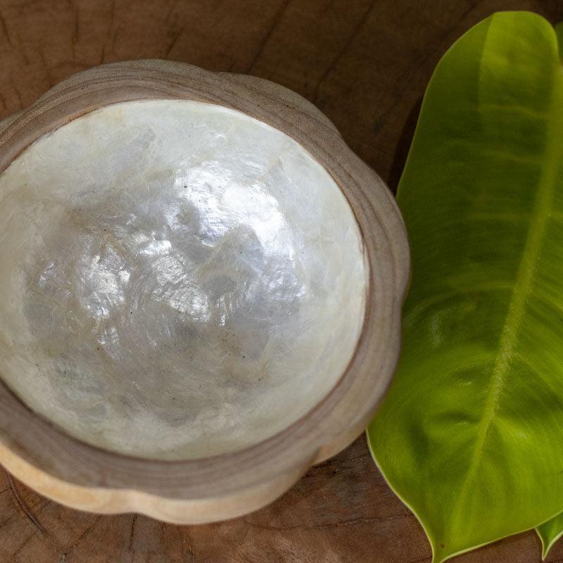 Tigela artesanal em madeira clara com acabamento interno madrepérola.