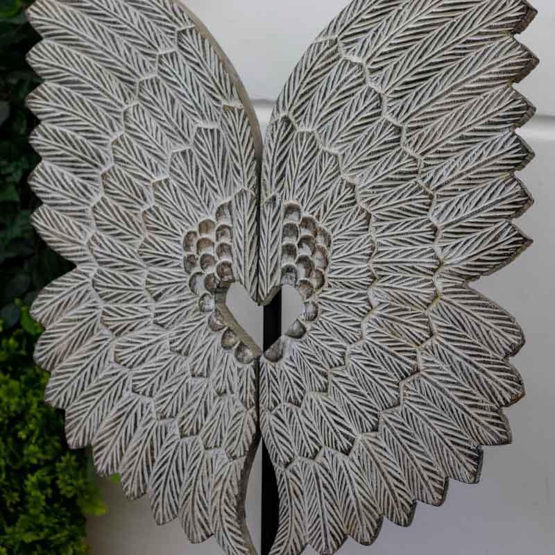 Peça de parede artesanal de Timor entalhada em madeira branca com relevo minucioso de penas.