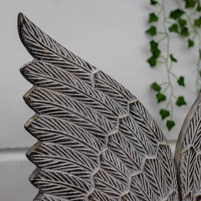 Objeto de decor em formato de asas de anjo com pátina clara e suporte de ferro de mesa.