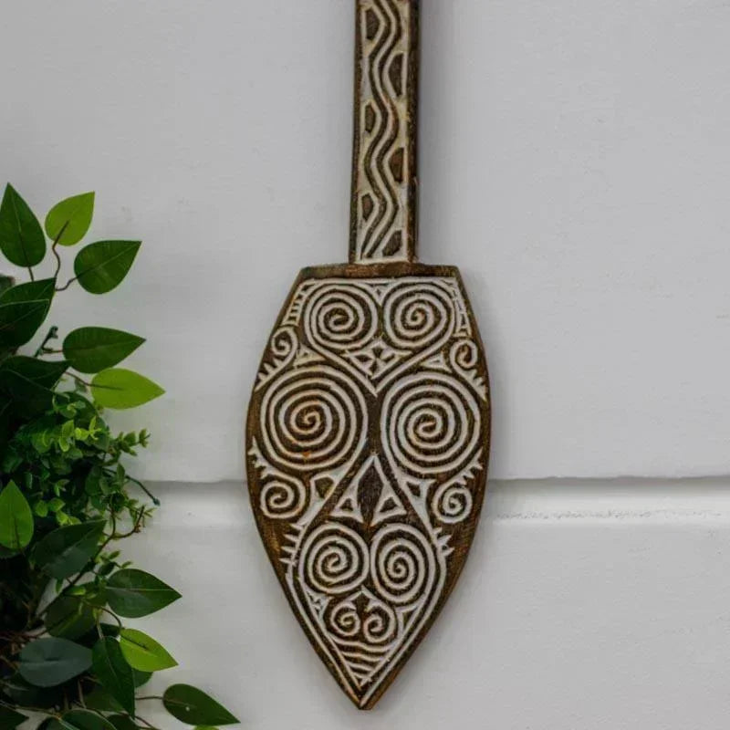 Obra cultural de Timor: remo de madeira com entalhes tribais decorativos.