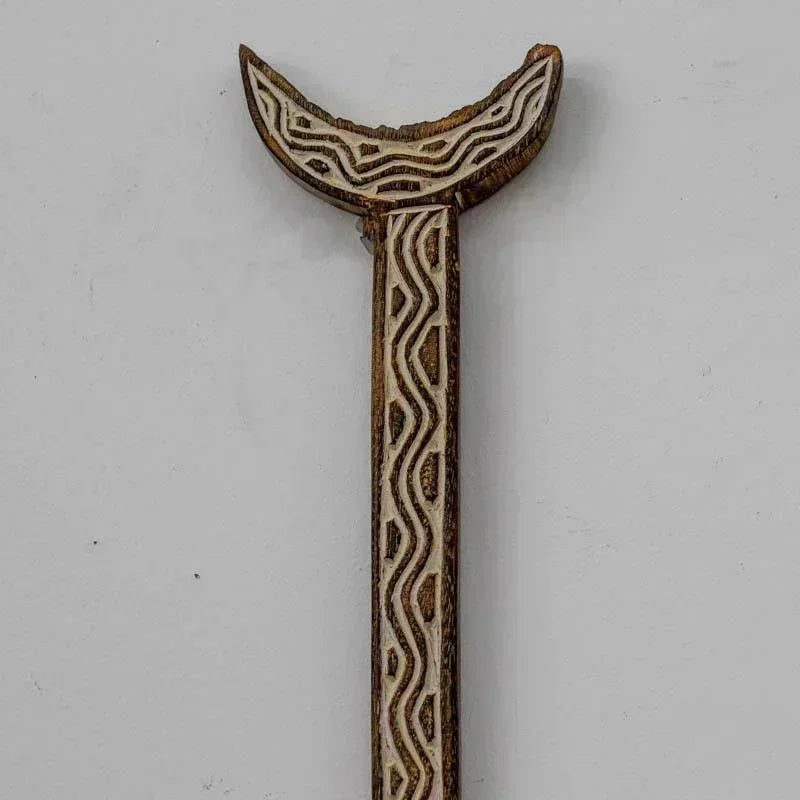 Remo artesanal timorense em madeira com padrões étnicos entalhados.