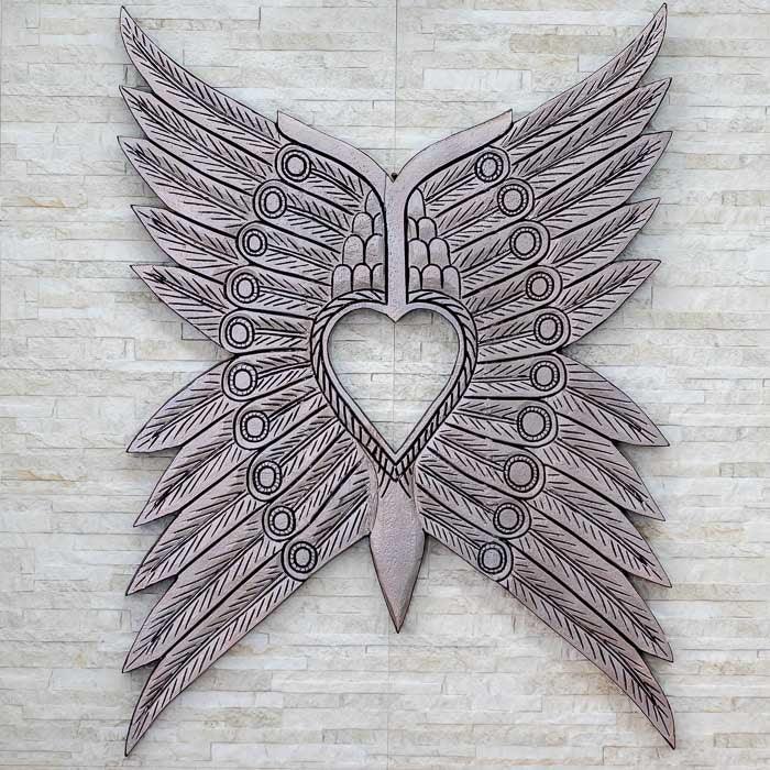 Escultura Asas Bornéo entalhada à mão em madeira natural da Indonésia, com traços tribais que simbolizam liberdade e espiritualidade ancestral.