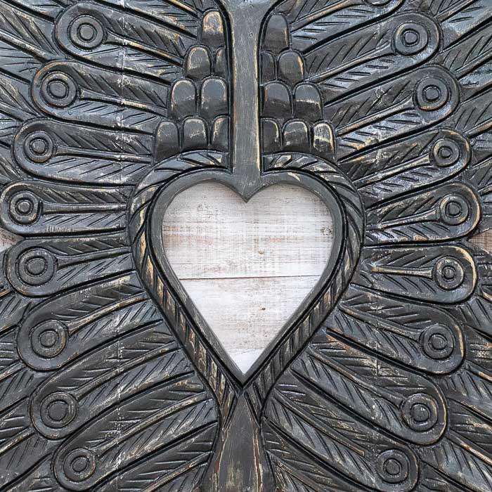 Escultura em madeira entalhada feita à mão em Bornéu, Indonésia, representando asas espirituais com textura natural e valor cultural profundo.