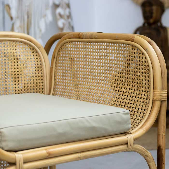 Poltrona de rattan para decoração boho, feita à mão, em ambiente com tapete orgânico.