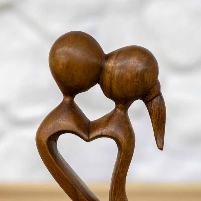 Estatueta decorativa namorados unido em um beijo formando um coração central em tom mel.