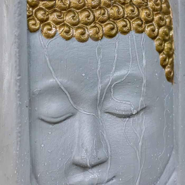 Face de Buda em fonte de parede estilo Bali, água fluindo em cascata delicada.