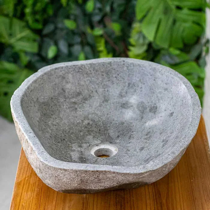 Pia de pedra com textura rústica ideal para lavabos tropicais
